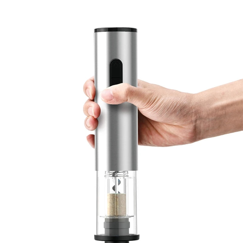 Hand holding a silver electric wine opener on a white background